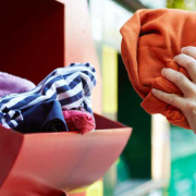 Garments being placed in clothing recycling bin.